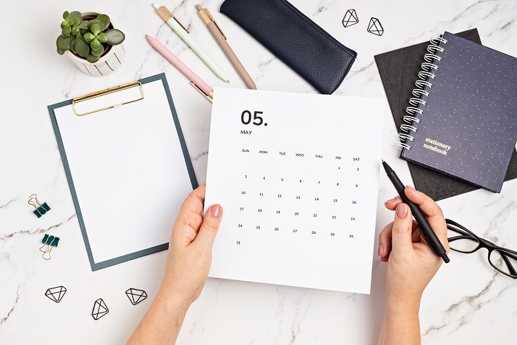 Desktop with calendar for may and office supplies. home office, social media blog, schedule, planning concept. Flatlay, top view